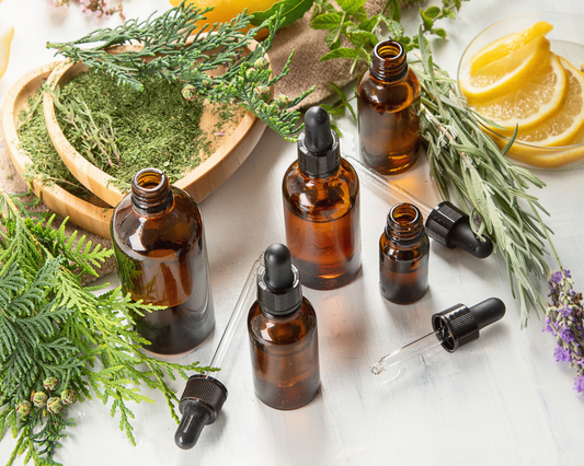 glass bottle tinctures with herbs surronding it 