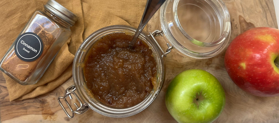 Apple butter, apples and cinnamon on a cutting board