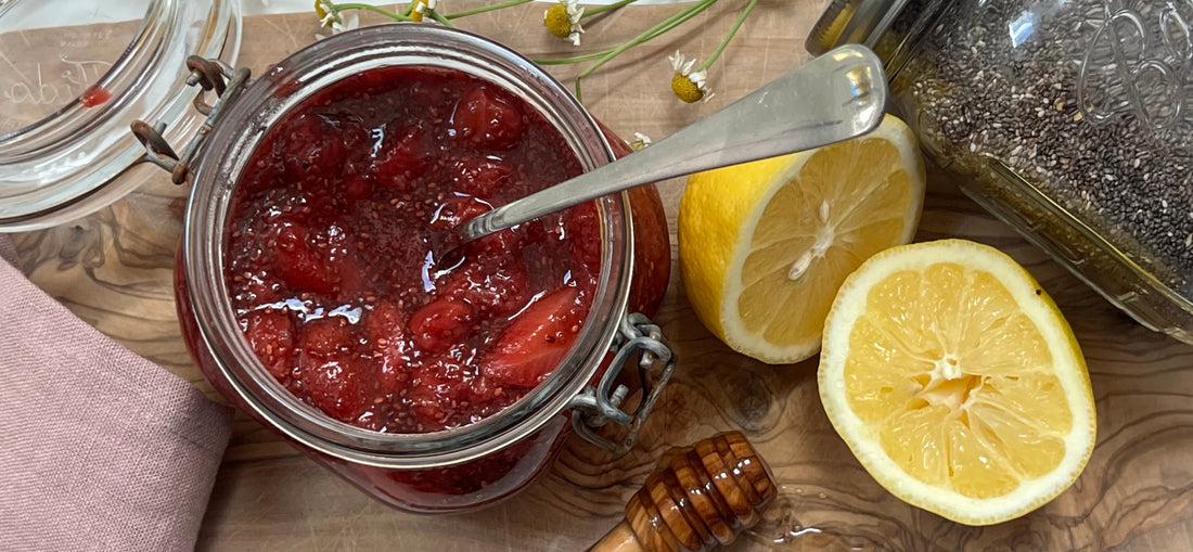 Stawberry chia seed jam on a cutting board with lemon, honey and chia seeds 