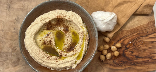 Hummus in a bowl, with olive oil and paprika on top. 