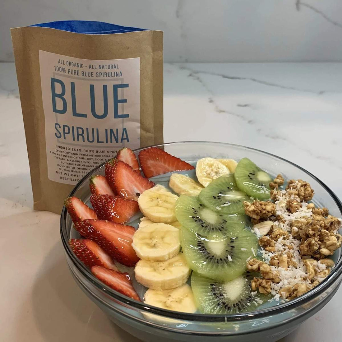 Blue Spirulina powder package with spirulina and fruit smoothie bowl