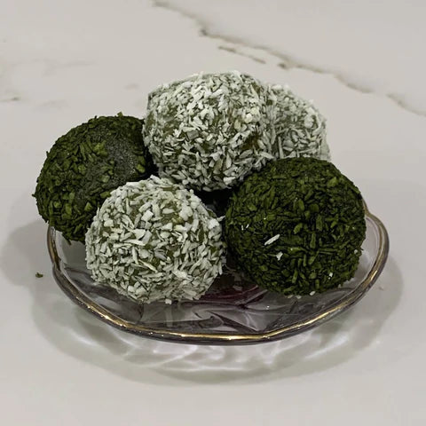 5 matcha energy balls stacked on a small glass plate