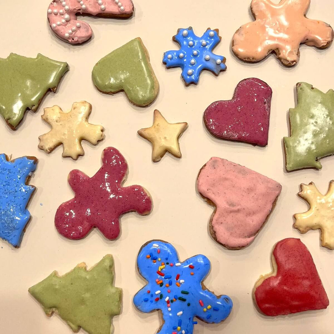 various sugar cooking frosted with natural food color frosting. The cookies are shaped as stars, gingerbread men, candy canes, hearts and trees.