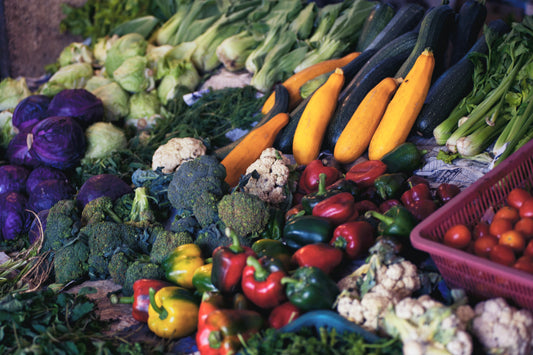 A photo with multiple vegetables such as cucumber, brocoli, capsicums, tomatoes.