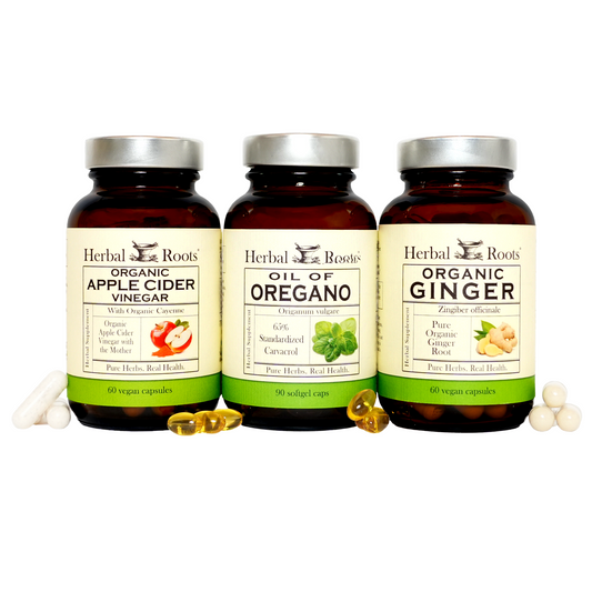 Three bottles of supplement capsules labeled Herbal Roots Organic Apple Cider Vinegar, Oil of Oregano, and Organic Ginger, with capsules in front of each bottle.